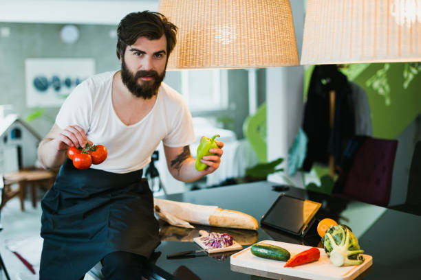 istock Handsome bearded man reading recipe from a digital tablet and preparing food 1046187744