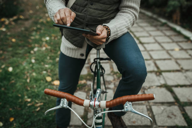 istock Fashionable man with a bicycle using digital tablet in the public park 1046207954