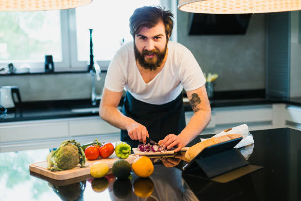 istock Handsome man cooking vegetable meal in the kitchen 1046212554