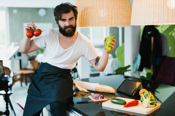 istock Handsome man cutting vegetables in the kitchen to prepare healthy dinner 1046218212