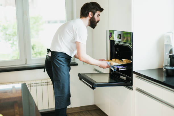 istock Bearded man with an apron baking pastries in the kitchen 1046234724