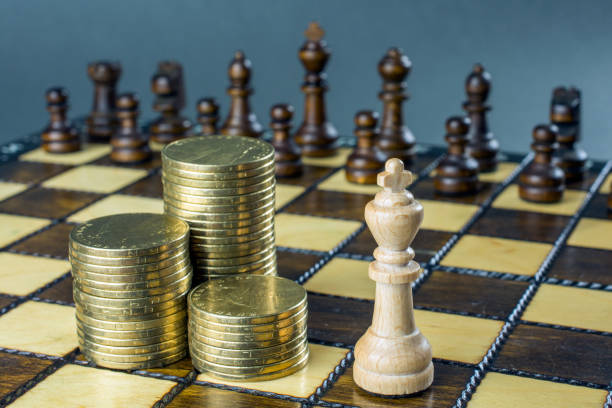 istock chess game, chess board with placed figures, piles of gold coins, 1046248462