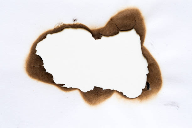 burned hole on piece of paper isolated on white background.