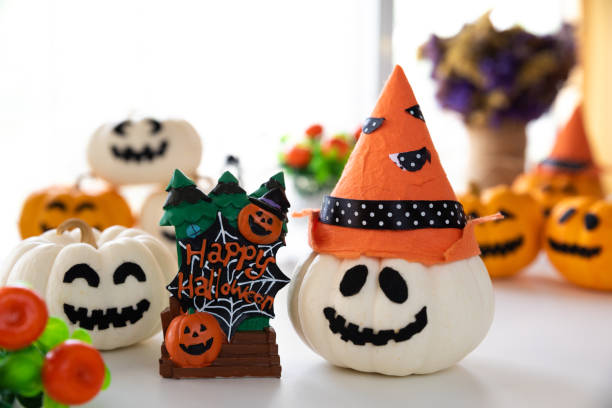 istock White and yellow ghost pumpkins with witch hat and Happy halloween text on borad. halloween concept. 1046249142
