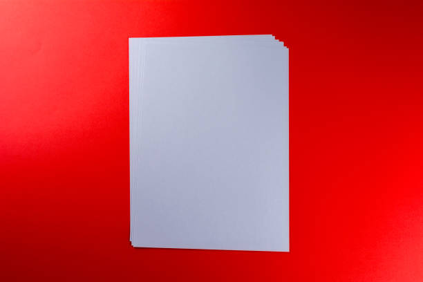 istock Blank sheets of paper red background 1046249594