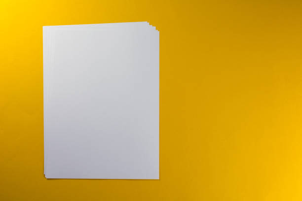 istock Blank sheets of paper yellow background 1046249868