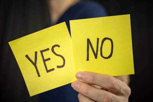 istock Man holds yellow sticker inscription Yes No. 1046252090