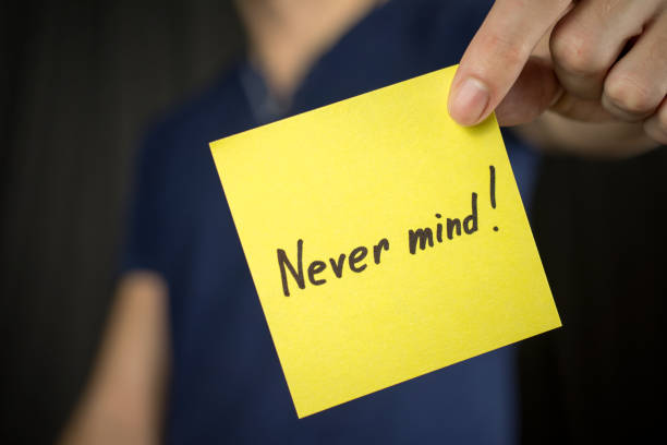 istock Man holds yellow sticker inscription Never mind!. 1046252092