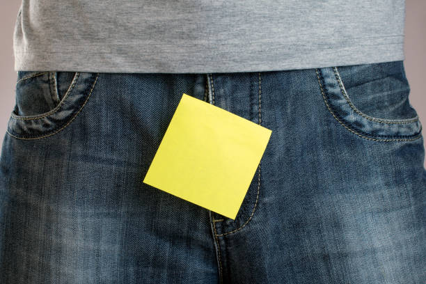 istock yellow sticker attached to mens jeans. 1046255828