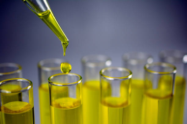 istock Glass test tubes with laboratory yellow liquids, drops from a pipette. 1046256604