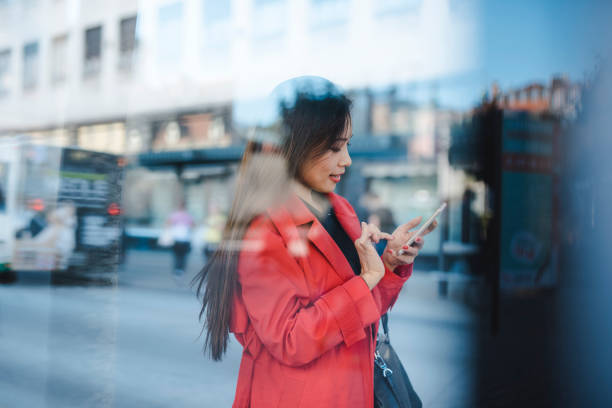 istock Businesswoman using smart phone while waiting for a bus 1046259226