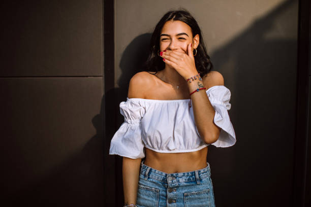 Portrait Of Cheerful Cute Italian Woman Portrait Of Cheerful Cute Italian Woman Giggling While Posing Against Wall white shirt black skirt stock pictures, royalty-free photos & images