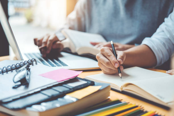 istock High school or college students studying and reading together in library 1046283542