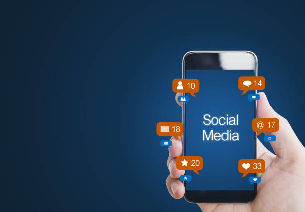 istock Hand using social media on mobile smart phone with notification icons, on blue background 1046306854