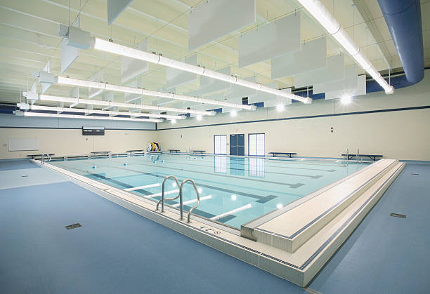 istock Brightly lit blue indoor swimming pool 104631292