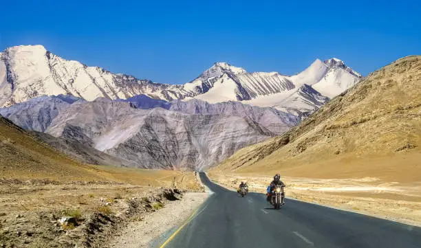 Indian tourists enjoy bike ride on national highway with scenic landscape at Ladakh India.