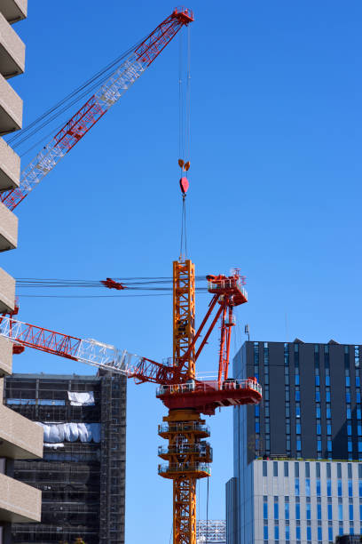 istock Crane of large construction site against clear sky. 1046335432