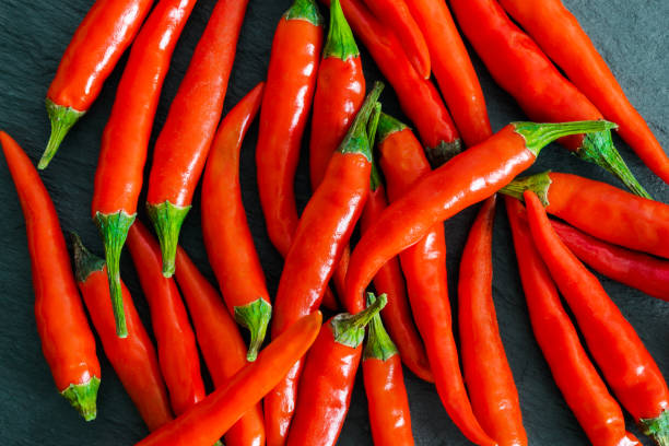 istock Chili peppers background on black rock surface 1046340614