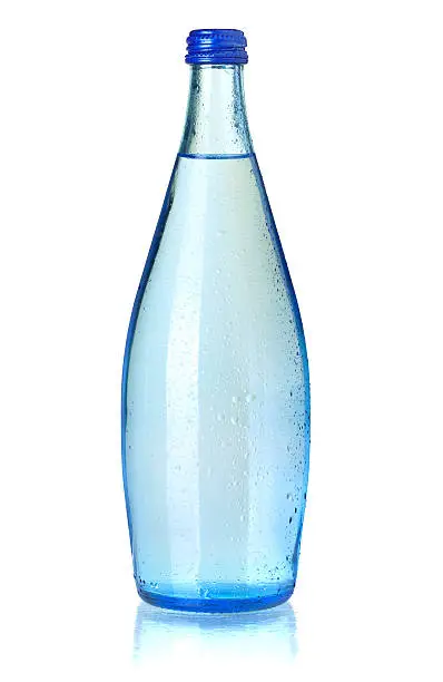 Glass bottle of soda water with water drops. Isolated on white background