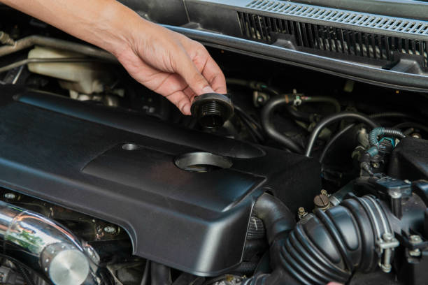 istock Human hand is opening the car engine oil cap to check the machine 1046345854