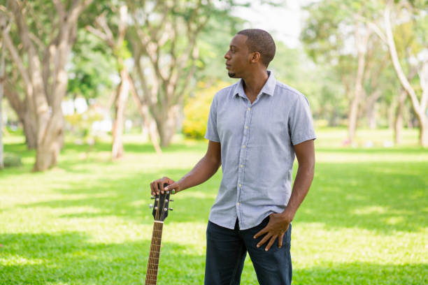 homme noir grave guitare en tenant par la tête d’attelage dans le parc - musical instrument nature outdoors musician photos et images de collection