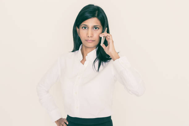 istock Serious Indian Business Lady Calling on Smartphone 1046360514