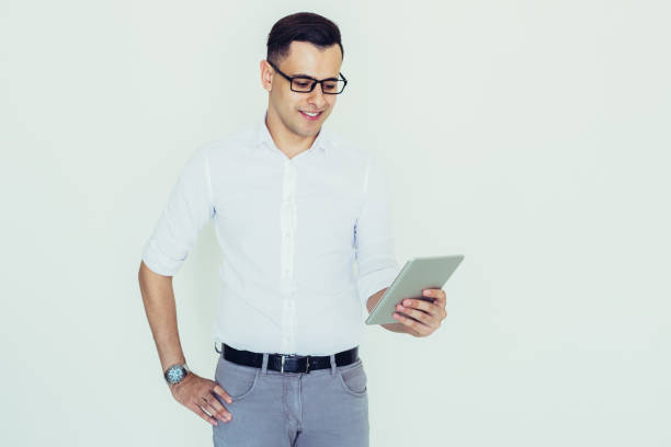 istock Smiling Handsome Business Man Holding Tablet 1046360540