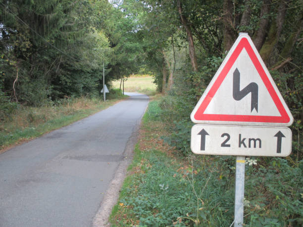 istock Winding countryside road  Lined with trees  Road sign 1046363522
