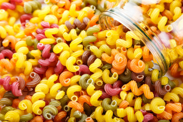 istock Multicolored spiral pasta is scattered as a background. close-up. 1046366062