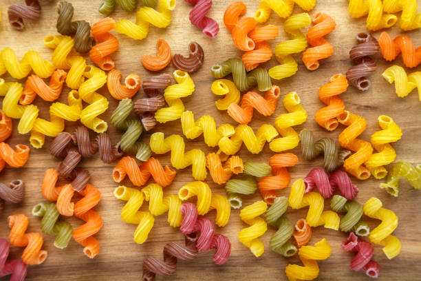 istock Multicolored spiral pasta is scattered as a background. close-up. 1046366142