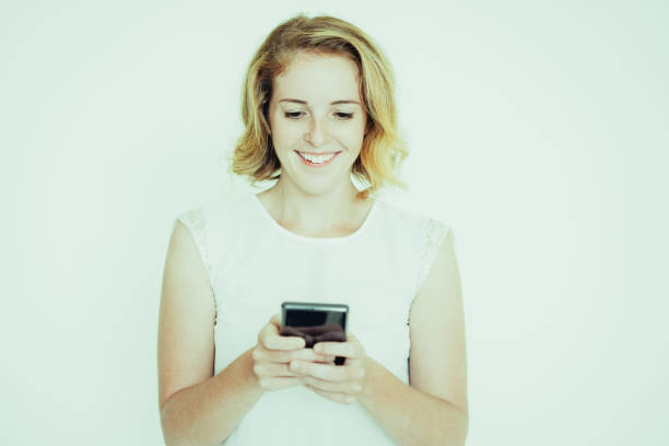 istock Smiling Pretty Woman Texting on Smartphone 1046366710