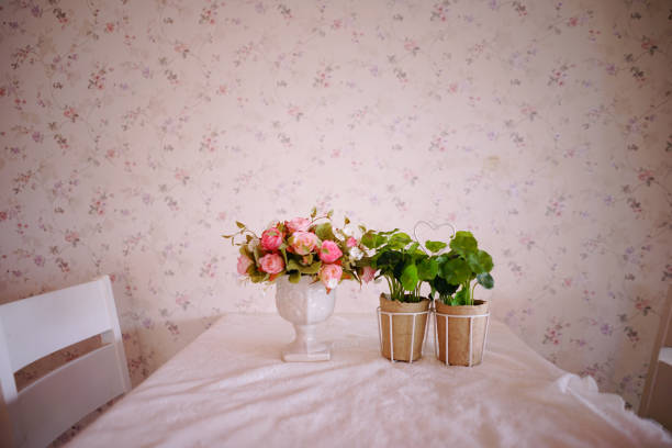 Wooden table with vintage vase plastic plant on blur bedroom
