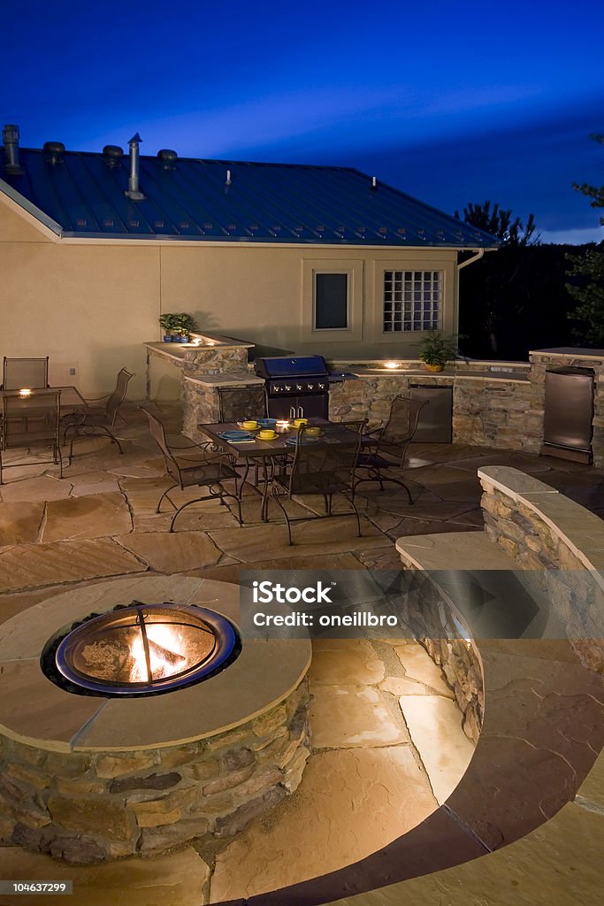 Backyard at dusk with fire pit beautiful backyard at dusk with fire pit, outdoor kitchen and seating Kitchen Stock Photo