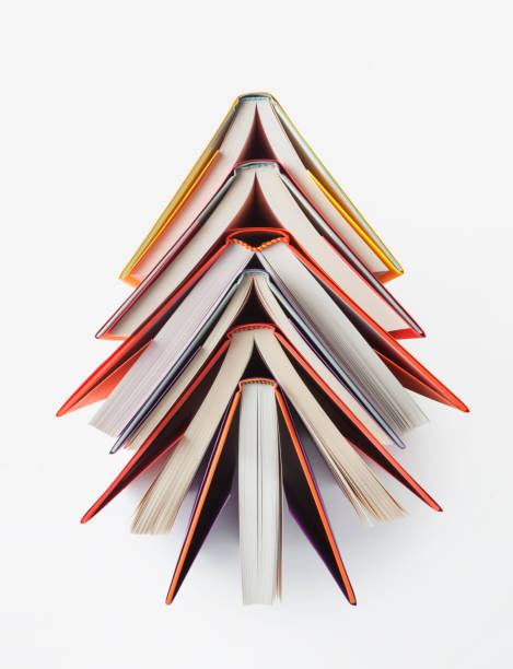Christmas tree made out of books on white background