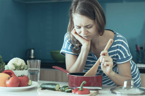 istock Dissatisfied Woman Cooking and Looking into Pan 1046382974
