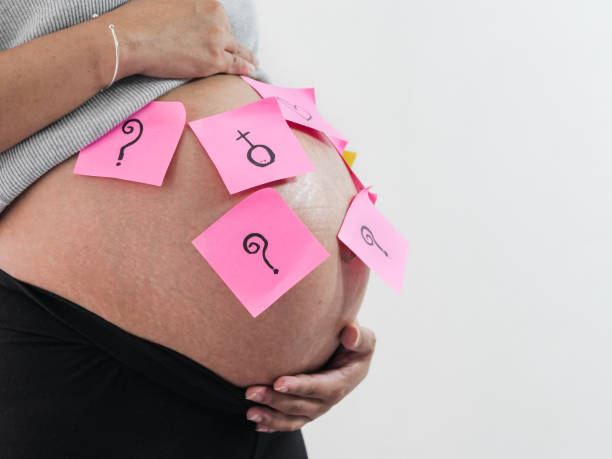 istock Body part pregnant belly with pink sticky notes on white background. 1046387944