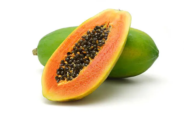 Half cut and whole papaya fruits on white background