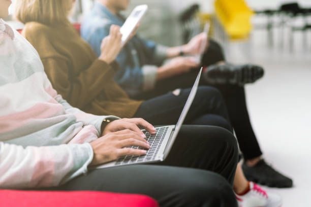 istock Group of friends sitting on sofa using laptop and smartphone technology 1046397702