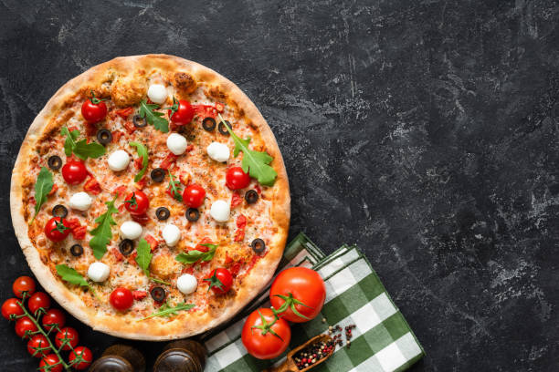 istock Tasty pizza on black concrete background, top view 1046403902