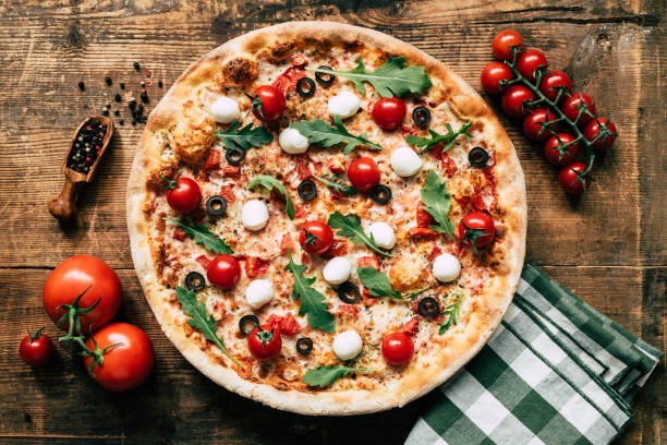 istock Italian pizza on old wooden background, top view 1046403904