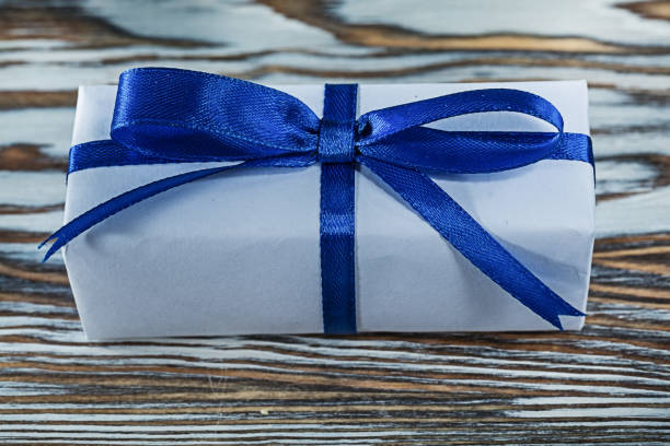 istock Blue gift box with tied bow on vintage wooden board 1046405562