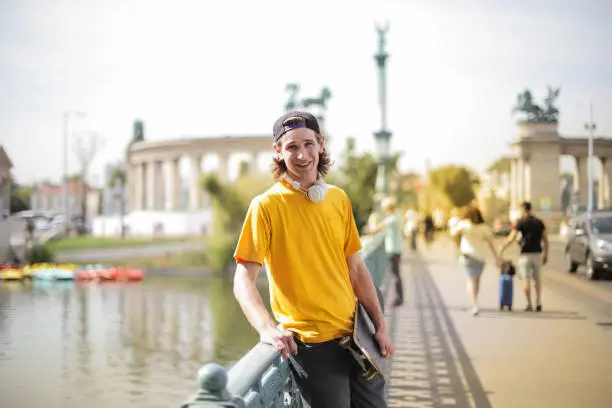 Young man in yellow t-shirt smiling on the street