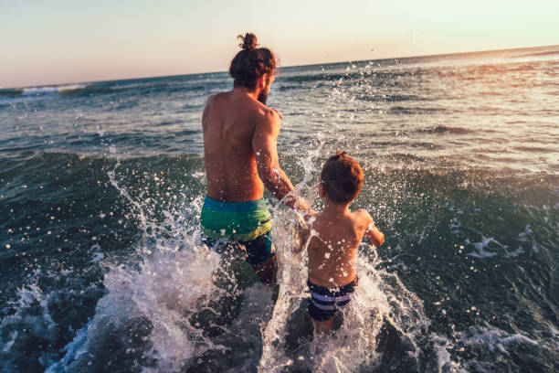 istock Father and son playing on the beach at the day time 1046410200