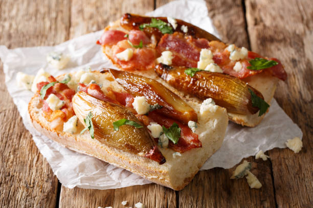 sandwiches with caramelized shallots, fried bacon and roquefort cheese close-up. horizontal - onion caramel appetizer bread imagens e fotografias de stock