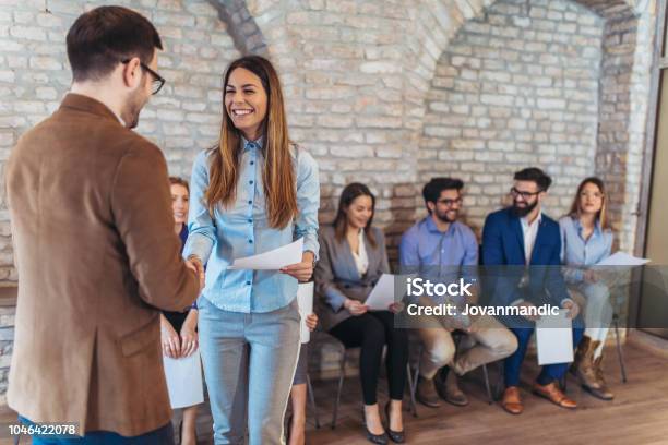 Hombre De Negocios Dando La Mano Con La Mujer Además De Gente Esperando Para La Entrevista De Trabajo En Una Oficina Moderna Foto de stock y más banco de imágenes de Entrevista de trabajo