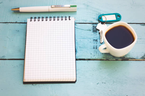 istock coffee cup, pen, key, calculator and notebook in blue table 1046427800