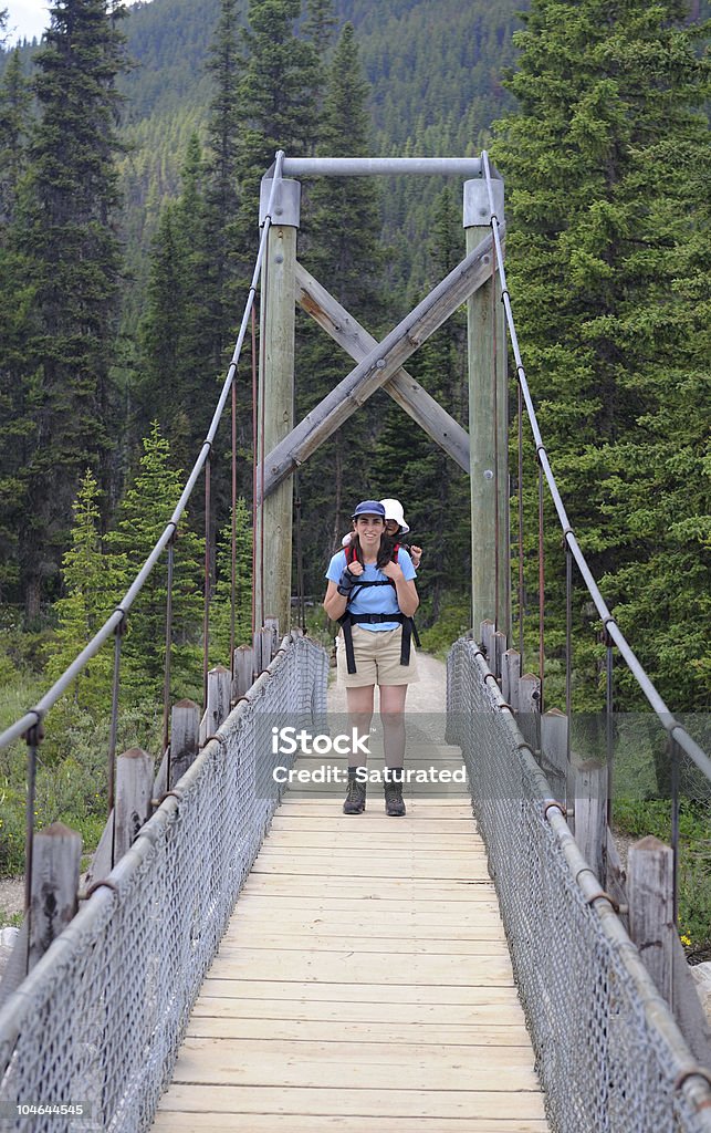 Caminhada na ponte mãe com a filha da criança mochila - Foto de stock de Adoção royalty-free