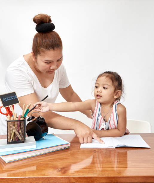 istock Mon and child girl thai doing homework at home 1046458288