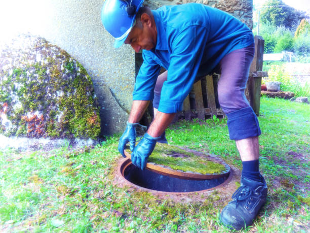 istock A worker in a special garment for construction works opens a manhole in to descend underground 1046465174
