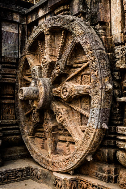 Carved chariot wheel on Konark Sun Temple, Odisha, India The temple complex , all carved from stone, has the appearance of a chariot with immense wheels and horses and was declared Unesco heritage site odisha stock pictures, royalty-free photos & images